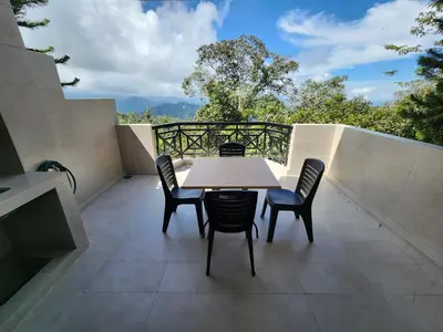 a table and chairs on the balcony of a house at Little England B3 in Bukit Fraser
