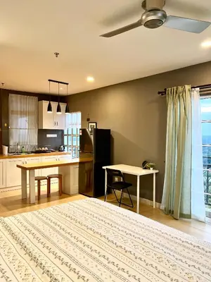 a living room with a table and a kitchen at High floor Mountain view Kampar in Kampar