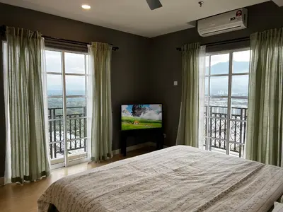 a bedroom with a bed and a television with windows at High floor Mountain view Kampar in Kampar