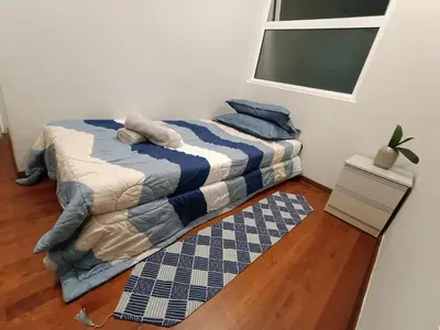 a bedroom with a bed and a rug at The Ipoh All Suite Resort, Jalan Haven Ipoh in Ipoh