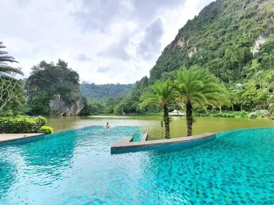 a swimming pool in the middle of a river with mountains at The Ipoh All Suite Resort, Jalan Haven Ipoh in Ipoh