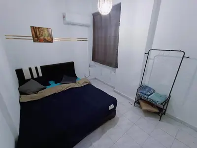 a bedroom with a black bed and a window at Cozy 3 Bedroom Apartment Bandar Perda BM in Bukit Mertajam