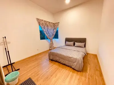 a bedroom with a bed in a room with a window at The Misty Penthouse in Tanah Rata