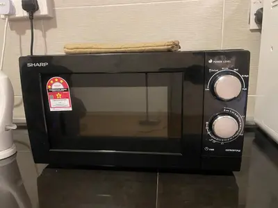 a black microwave with a towel on top of it at The Misty Penthouse in Tanah Rata