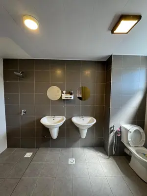 a bathroom with two sinks and a toilet at The Misty Penthouse in Tanah Rata
