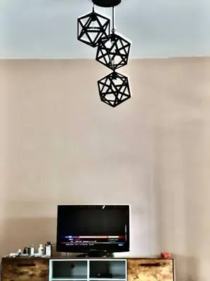 a room with a television and a chandelier hanging from the ceiling at SUPER COMFY HOME @ KULIM CITY in Kulim