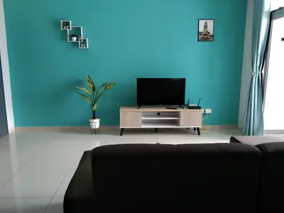 a living room with a tv and a blue wall at HK Homestay in Ipoh