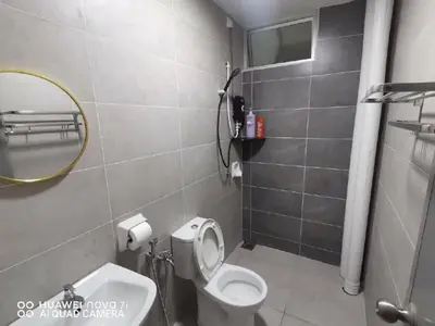 a bathroom with a white toilet and a mirror at HK Homestay in Ipoh