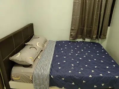 a small bedroom with a bed with a blue comforter at QQ Homestay in Ipoh