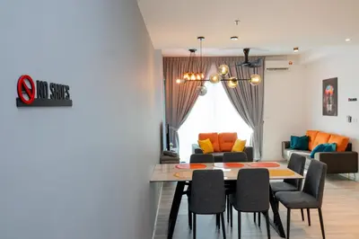 a dining room and living room with a table and chairs at Ipoh Tambun Lost World Sunway Onsen Suites Lana 2R2B 8 paxs in Tambun