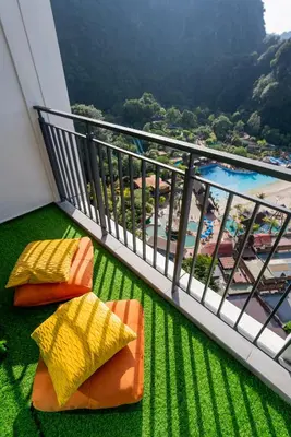 a balcony with two chairs and a swimming pool at Ipoh Tambun Lost World Sunway Onsen Suites Lana 2R2B 8 paxs in Tambun