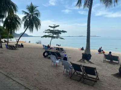 a group of people sitting in chairs on a beach at Nur's Homestay in Seri Manjung