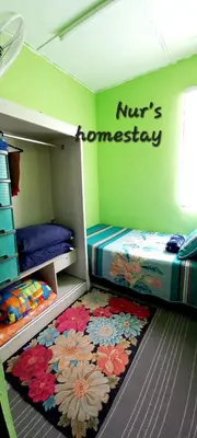 a bedroom with two bunk beds and a rug at Nur's Homestay in Seri Manjung