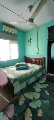 a bedroom with a large bed with a flower carpet at Nur's Homestay in Seri Manjung