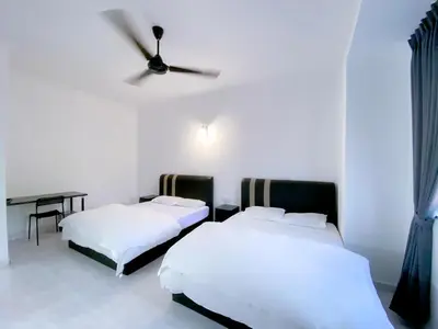 two beds in a room with a ceiling fan at Venice Guest Hostel - Bilik Sahaja in Lumut