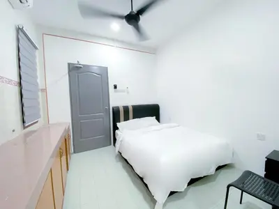 a white bedroom with a bed and a door at Venice Guest Hostel - Bilik Sahaja in Lumut