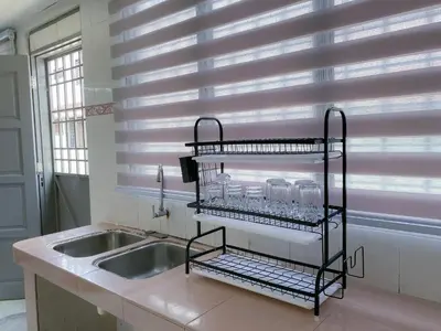 a kitchen with a sink and a shelf with glasses at Venice Guest Hostel - Bilik Sahaja in Lumut