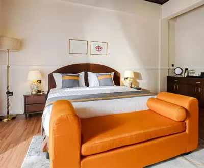 a bedroom with a large bed with an orange couch at SPRINGHILL RESORT in Cameron Highlands