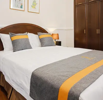 a bedroom with a large white bed with yellow and gray pillows at SPRINGHILL RESORT in Cameron Highlands