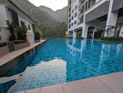 a swimming pool in a hotel with mountains in the background at Amazing Views & Eco Friendly Luxury Onsen Suites, Lost World of Tambun in Ipoh