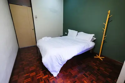 a bed with white sheets and pillows in a room at monstera homestay near Tambun, Ipoh Garden East in Ipoh