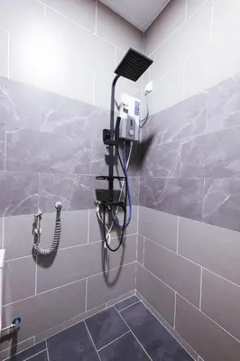 a shower with a hose in a bathroom at monstera homestay near Tambun, Ipoh Garden East in Ipoh