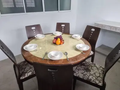 a wooden table with a bowl of fruit on it at Sweet 3 bedroom home @ Canning Garden, Ipoh in Ipoh