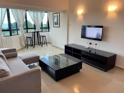 a living room with a tv and a couch and a table at The Ferringhi Sea View 777 in Batu Ferringhi
