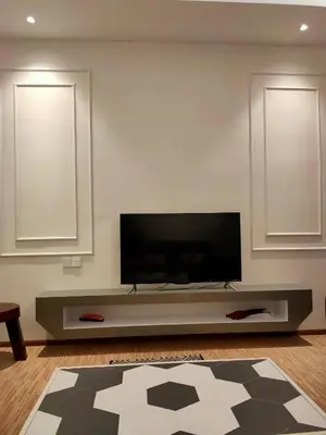 a living room with a flat screen tv on a wall at Cameron Lovely Cottage 3 Rooms in Tanah Rata
