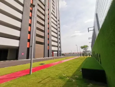 a building with a grassy area next to a building at Starlight Homestay The Venus Sitiawan in Seri Manjung