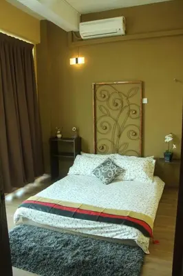 a bedroom with a bed with a large headboard at 1 MINUTES TO TOWER SENTRAL INTAN HOMESTAY 6 ROOMS in Teluk Intan