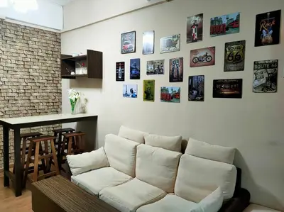 a living room with a white couch and pictures on the wall at 1 MINUTES TO TOWER SENTRAL INTAN HOMESTAY 6 ROOMS in Teluk Intan