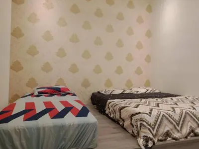 two beds sitting next to each other in a bedroom at Muslim Homestay blue Adik Aisyah Apartment in Tanah Rata