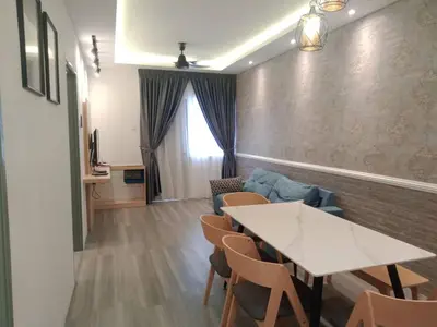 a dining room with a white table and chairs at Muslim Homestay blue Adik Aisyah Apartment in Tanah Rata