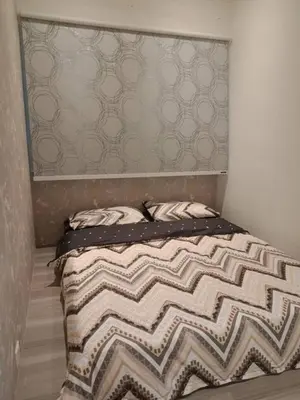 a bedroom with a bed with a brown and white comforter at Muslim Homestay blue Adik Aisyah Apartment in Tanah Rata