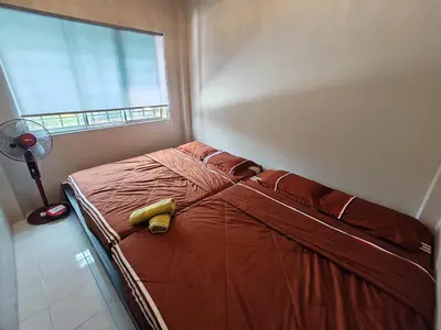 a bedroom with a bed with a yellow blanket and a window at ZE II Homestay_Cameron in Tanah Rata