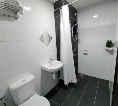 a white bathroom with a toilet and a sink at IPOH CITY CENTRE Majestic Homestay Pool View 3 mins Walking to Famous Food Places & 15mins to Old Town Ipoh by Happy Homestay in Ipoh
