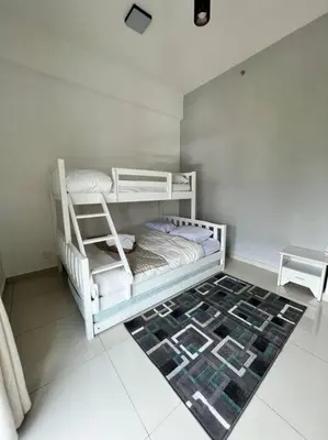 a white bunk bed in a room with a rug at Lily Ville in Tanah Rata