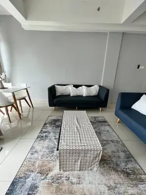 a living room with a couch and a rug at Lily Ville in Tanah Rata