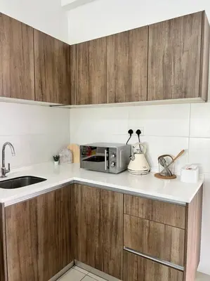 a kitchen with a sink and a microwave on a counter at Lily Ville in Tanah Rata