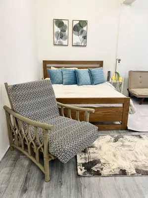 a bedroom with a bed with blue pillows and a chair at Roemah lily studio in Tanah Rata
