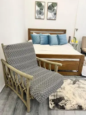 a bedroom with a bed and a chair in front of it at Roemah lily studio in Tanah Rata
