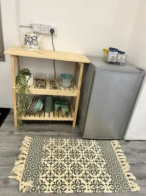 a room with a table and a rug on a floor at Roemah lily studio in Tanah Rata