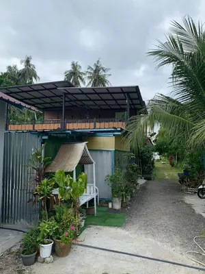 a house with a white bench in front of it at SABAYA HOMESTAY in Balik Pulau