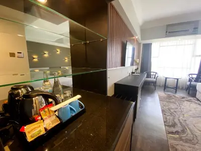 a kitchen with a counter top and a living room at Bertam Resort & Water Park Penang in Kepala Batas