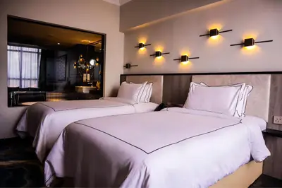 two beds in a hotel room with white sheets at Bertam Resort & Water Park Penang in Kepala Batas