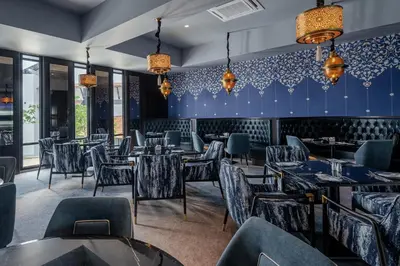 a restaurant with blue walls and tables and chairs at Bertam Resort & Water Park Penang in Kepala Batas