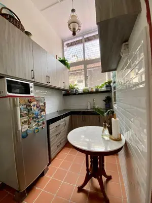 a kitchen with a table and a refrigerator at Pertak Siring at Kuala Kubu Bharu in Kuala Kubu Baharu