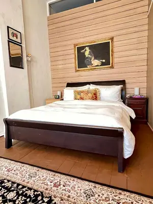 a bedroom with a bed with a painting on the wall at Pertak Siring at Kuala Kubu Bharu in Kuala Kubu Baharu