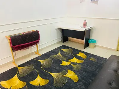 a room with a table and a rug with yellow leaves at NO 121 NAZIRIN HOMESTAY TMN DESA MANJUNG in Lumut